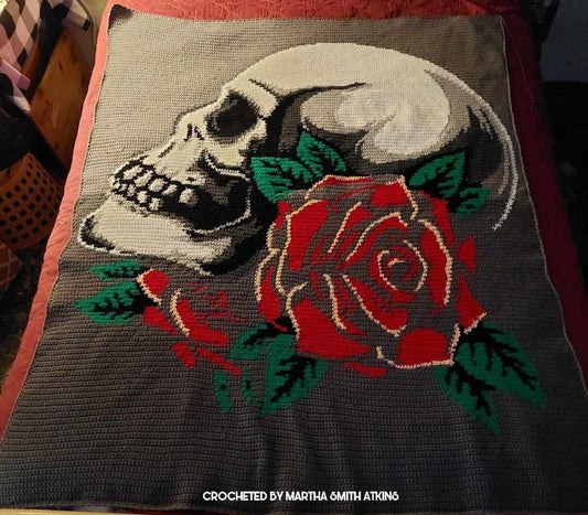 crochet graphghan blanet depicting a skull and a rose