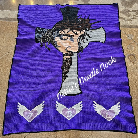 Purple blanket with embroidered design of a person with a top hat and decorative elements, branded 'Nellie's Needle Nook'. Jesus The Passion Of The Christ Crochet Graphghan Pattern by Geeky Graphghans. Crocheted by Nettie Godby