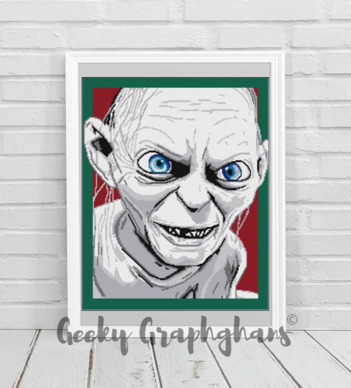 A crochet graphghan pattern depicting the character Gollum from The Hobbit and The Lord of the Rings, displayed on a white wall above a white countertop with a brick wall background.