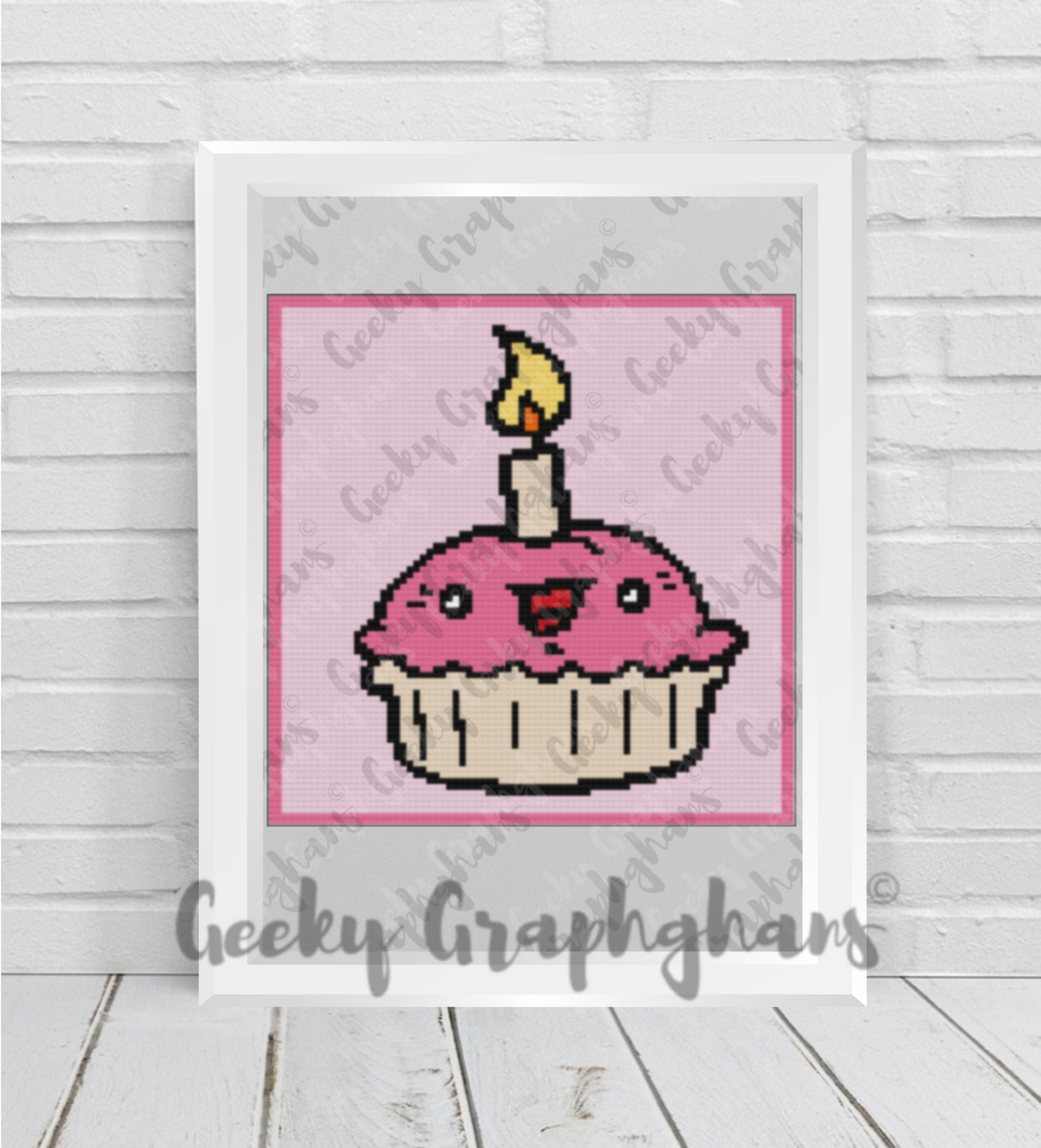 Crochet  design of a pink cupcake with a candle on a white background, framed by 'Geeky Graphghans'.