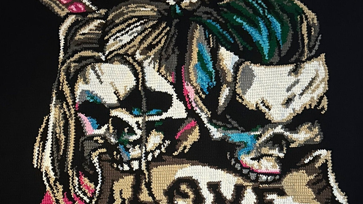 Embroidered design on a black fabric with colorful elements and text.