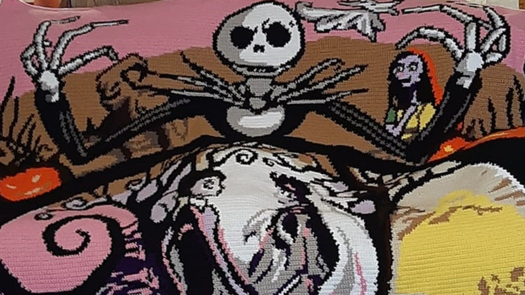 Crocheted blanket with characters from 'The Nightmare Before Christmas' on a couch.