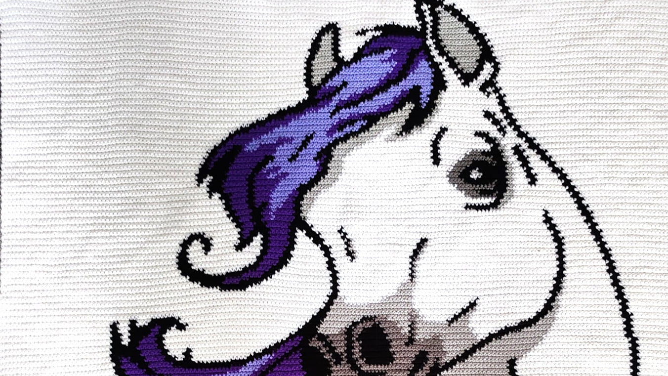 Crochet patch of a horse with purple hair on a white background