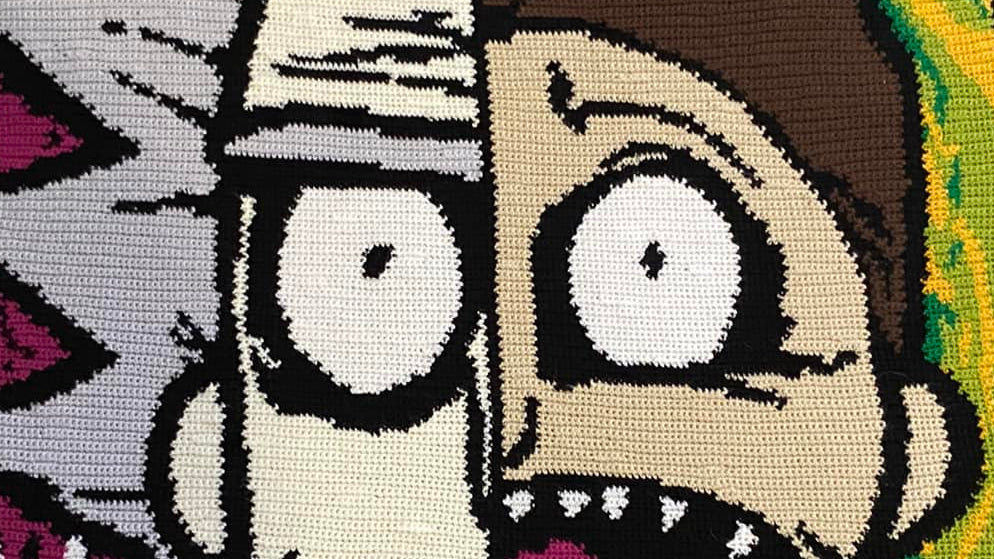 Blanket with a split design of two cartoon characters on a beige carpet.