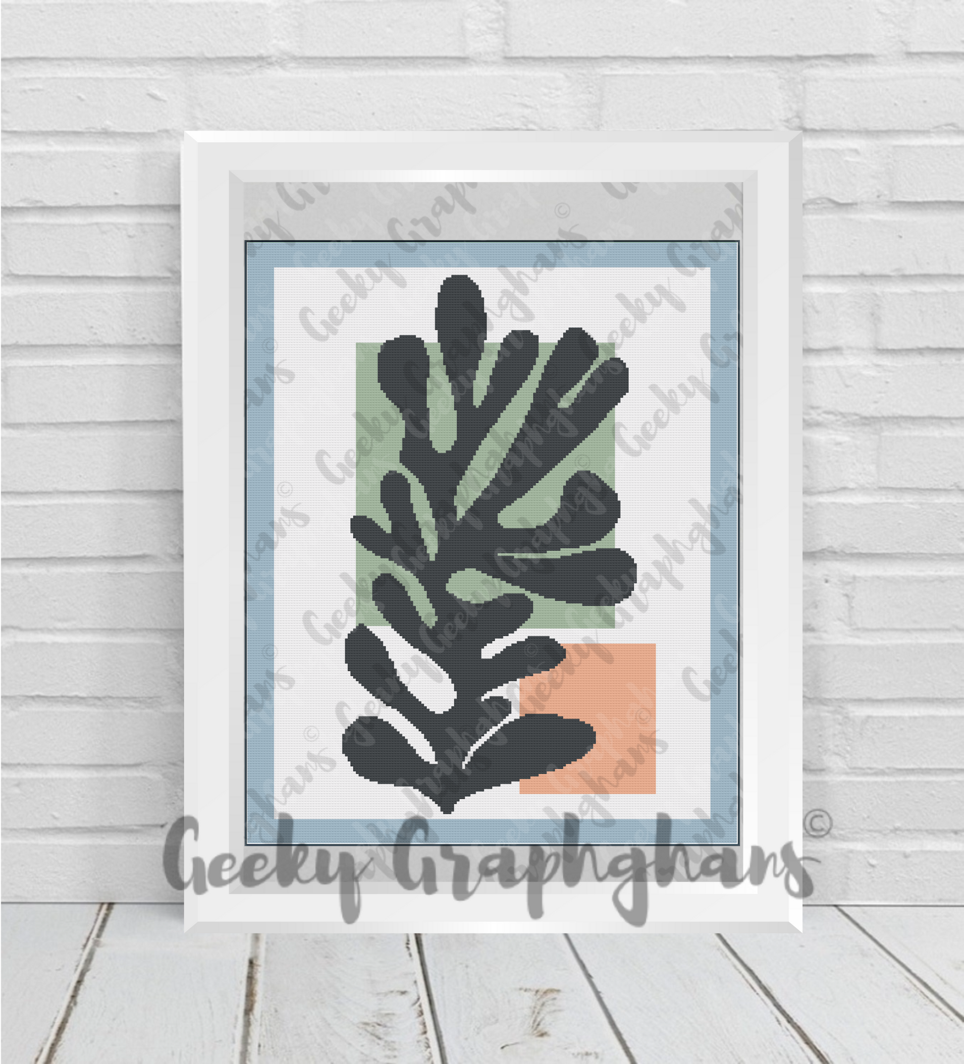 Framed artwork with black leaf design on a light gray background, branded 'Geeky Grapghans'. Crochet Graphghan pattern by Geeky Graphghans