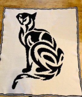 Black cat design on a white fabric with a brown border. Tribal cat crochet graphghan pattern by Geeky Graphghans. Crocheted by Norma Hodge