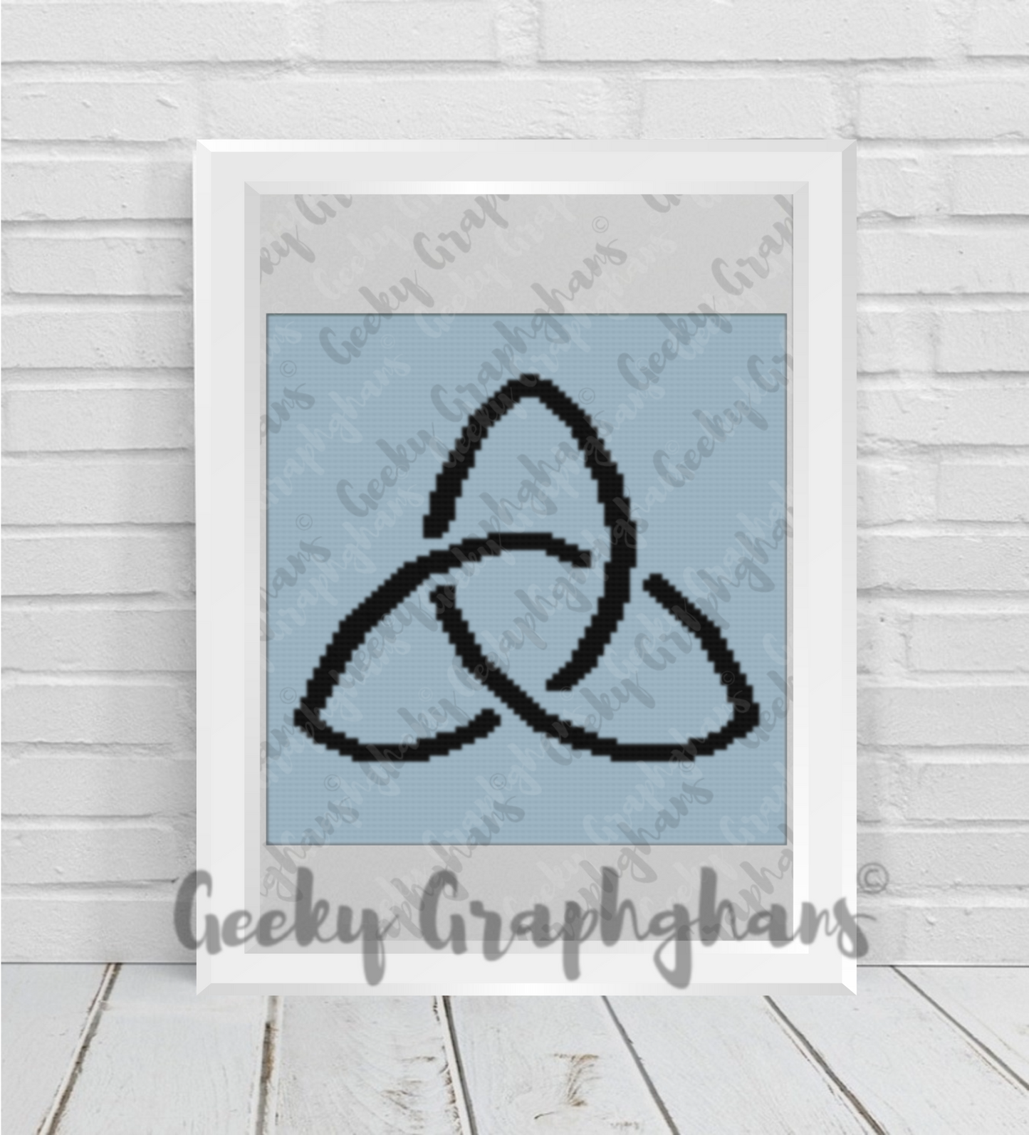Framed artwork with a black knot design on a light blue background, branded 'Geeky Graphhams'. Crochet pillow pattern - Trinity Knot
