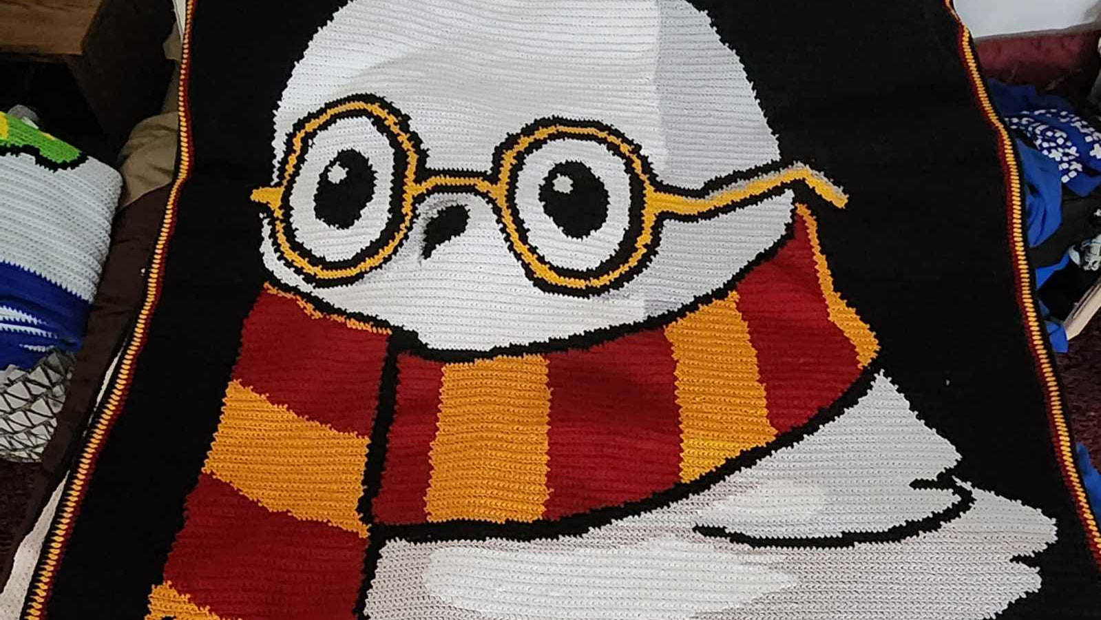 Crocheted blanket with an owl design wearing glasses and a scarf, with 'Happy Owlidays' text.