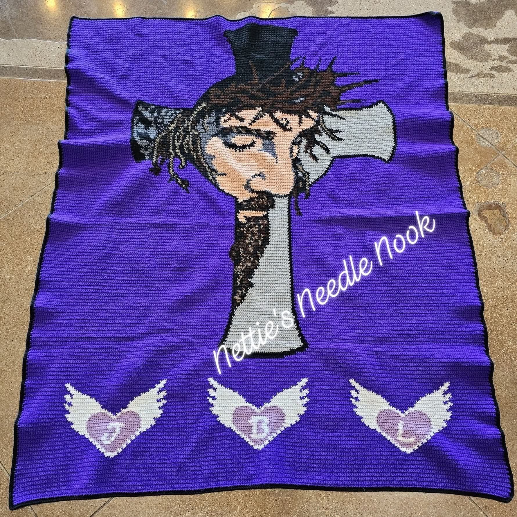 Purple blanket with embroidered design of a person with a top hat and decorative elements, branded 'Nellie's Needle Nook'. Jesus The Passion Of The Christ Crochet Graphghan Pattern by Geeky Graphghans. Crocheted by Nettie Godby